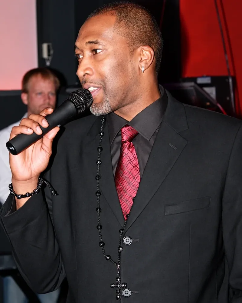Cory McGee speaking on stage with a microphone